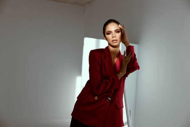 retrato de mujer de moda en traje sobre fondo oscuro chaqueta roja modelo - Foto, Imagen