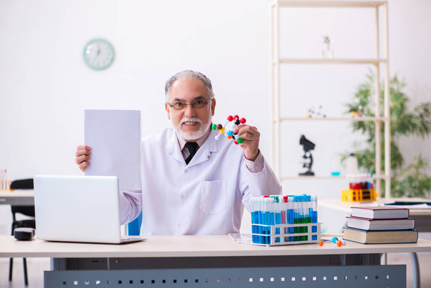 Antigo químico masculino segurando papel no conceito de inovação - Foto, Imagem