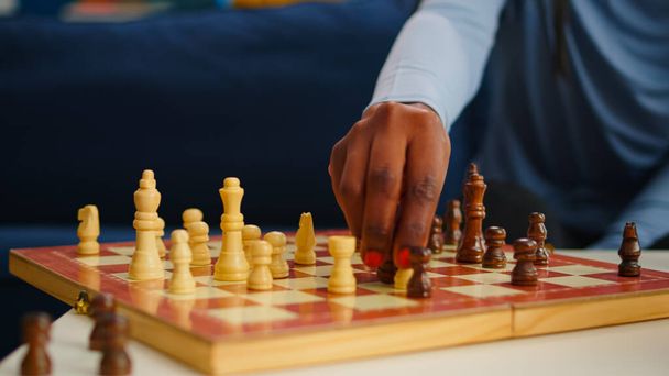 Primer plano de la mujer negra moviendo piezas de ajedrez a bordo - Foto, imagen