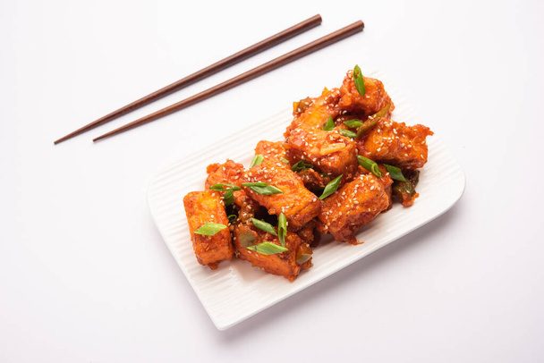 Crispy chilli paneer is a Indo Chinese starter or appetizer made by tossing fried cottage cheese in sweet sour and spicy chilli sauce, served in a plate. selective focus - Photo, Image