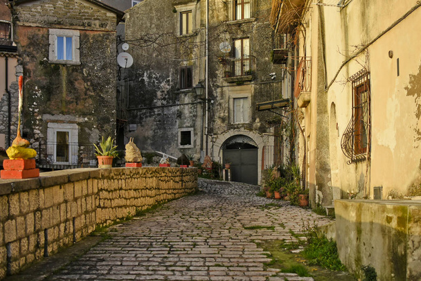 Een smalle straat tussen de oude huizen van Guardia Sanframondi, een bergdorp in de provincie Benevento, Italië. - Foto, afbeelding
