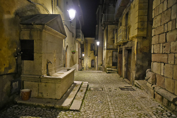 Een smalle straat tussen de oude huizen van Guardia Sanframondi, een bergdorp in de provincie Benevento, Italië. - Foto, afbeelding