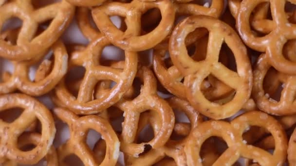 Close-up van gezouten hartige mini-pretzels in de traditionele lusvormige knoop. Bovenaanzicht. Rotatievideo - Video