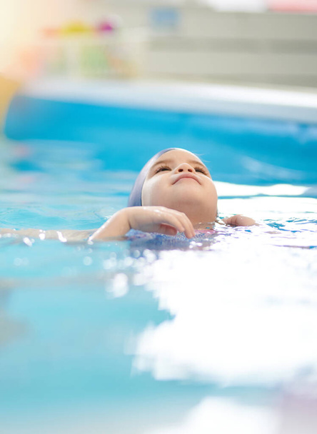 Portré a gyermek úszás vissza kék medence víz háttér - Fotó, kép
