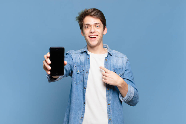 young boy feeling happy, surprised and proud, pointing to self with an excited, amazed look. telephone concept - Photo, image