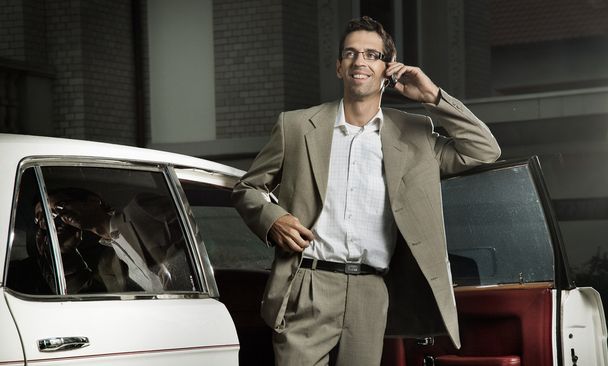 Young man speaking the phone next to the car - Foto, Imagen