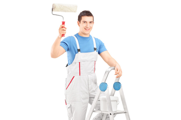 Painter holding roller on ladder - Foto, imagen