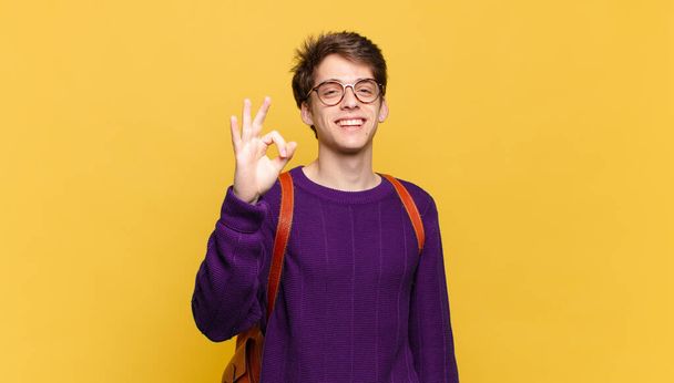 young student boy feeling happy, relaxed and satisfied, showing approval with okay gesture, smiling - Fotoğraf, Görsel
