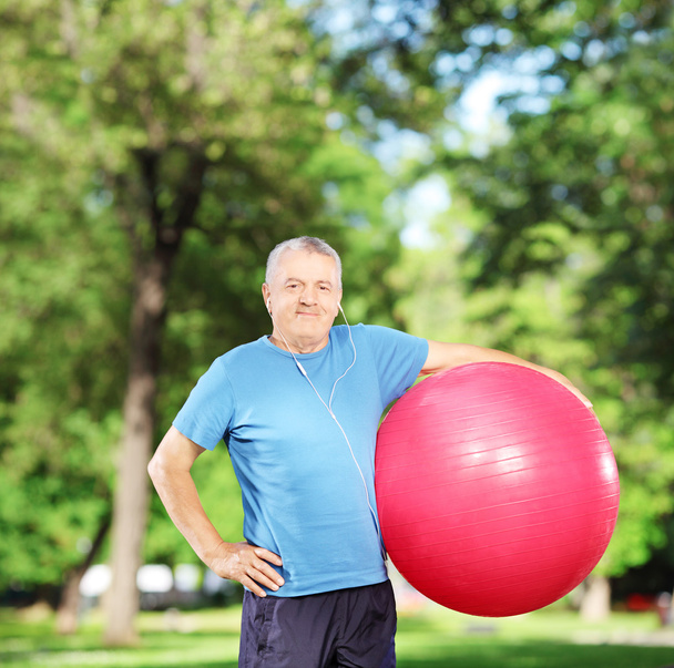 Mature man holding pilates ball - Fotoğraf, Görsel
