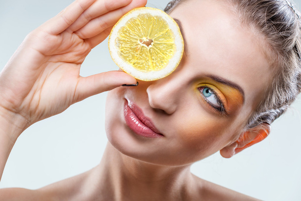 Beautiful woman with lemon and yellow makeup - Foto, afbeelding