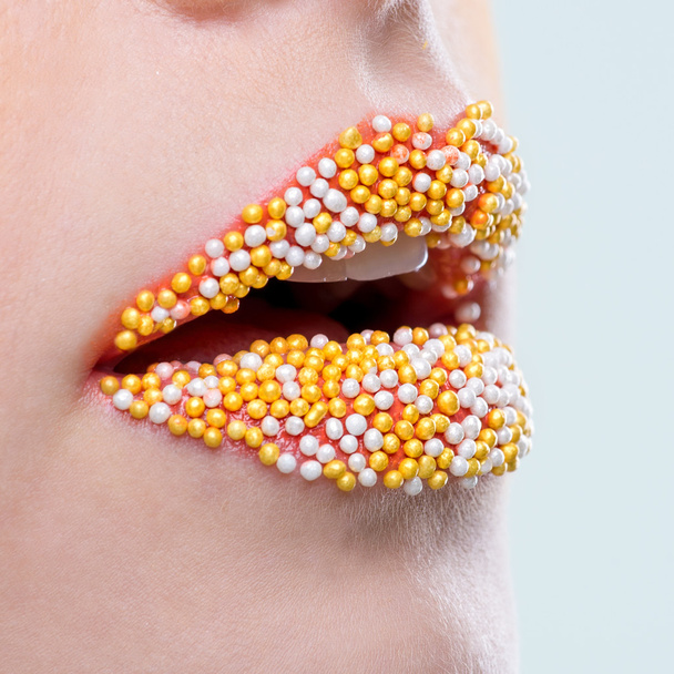 Красивые женские губы с жемчужной конфеткой
 - Фото, изображение