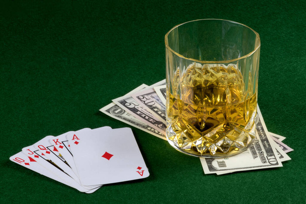 Карточная комбинация с долларами США и виски на столешнице - Фото, изображение