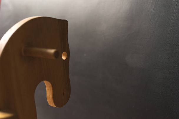 дерев'яна коняча іграшка ручної роботи для дітей на темній стіні, концепція копіювання вставки, дитинство
 - Фото, зображення