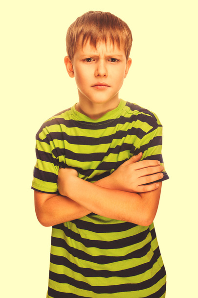böse unruhige böse dunkelblonde Kind in einem gestreiften grünen Hemd, iso - Foto, Bild