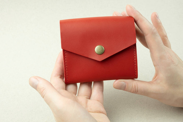 bright red leather wallet in female hands close-up - 写真・画像