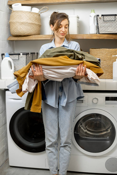 Portrait of a happy young housewife with clean clothes - Photo, Image