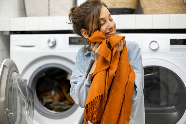 Dona de casa com lenço limpo fresco na lavanderia em casa - Foto, Imagem