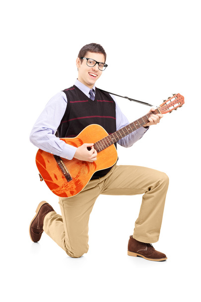 Man playing acoustic guitar and kneeling - Foto, imagen