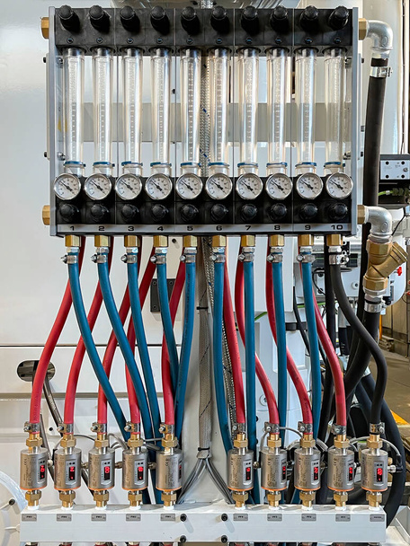 circuit avec tuyaux bleus et rouges reliant des éprouvettes graduées avec manomètres et régulateurs de température, système de refroidissement de moule de coulée sous pression, industrie automatisée 3.0, verticale - Photo, image