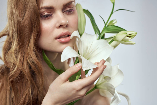 Encantadora dama con flores blancas retrato primer plano fondo claro - Foto, imagen