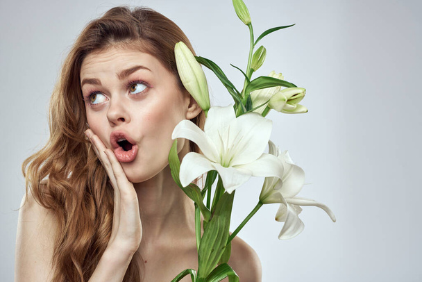Emotional woman with flowers spring model naked shoulders clear skin - Foto, Imagem