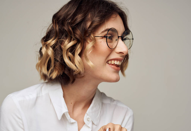 Emotional woman gestures with her hands on a gray background glasses on her face for hairstyle education - Zdjęcie, obraz