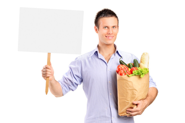 Male holding paper bag and blank panel - Zdjęcie, obraz