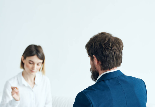 Egy nő dokumentumokkal hallgatja meg egy férfi problémáit egy könnyű hátterű pszichológussal. - Fotó, kép