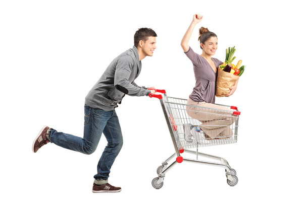 Person pushing woman in shopping cart - Fotoğraf, Görsel