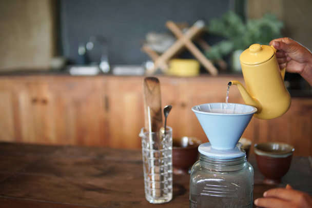 Barista bereitet brühenden Kaffee mit Kaffeemaschine und Wasserkocher zu. Tropfender gemahlener Kaffee mit Filter - Foto, Bild
