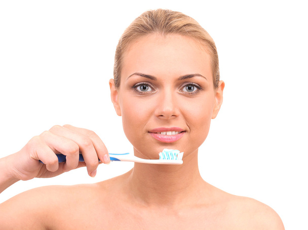 Attractive young woman with a toothbrush on white background close-up - Photo, image