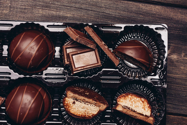 pasteles dulces dulces y cubos de chocolate en una mesa de madera - Foto, Imagen
