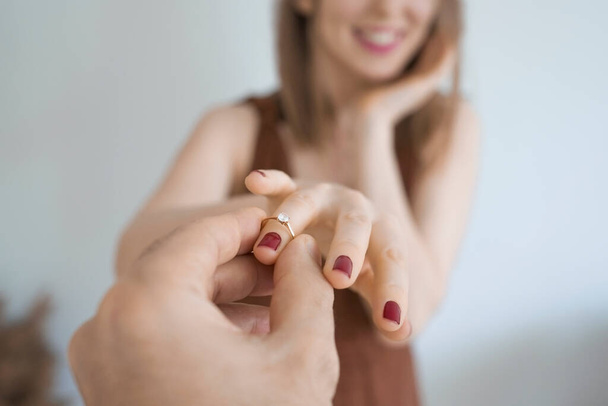 Um homem coloca um anel no dedo de uma mulher.O conceito de noivado, propostas de casamento e recém-casados - Foto, Imagem