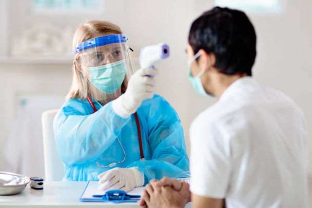 Doutor examinando paciente doente para coronavírus. Homem asiático na máscara facial na clínica de saúde para teste e triagem. Tratamento do vírus. pandemia de coronavírus. Surto de Covid-19. Tosse, dor no peito. - Foto, Imagem
