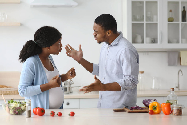Těhotná žena bojuje se svým manželem při vaření spolu - Fotografie, Obrázek