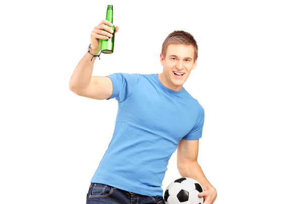 Fan holding beer and football - Foto, imagen