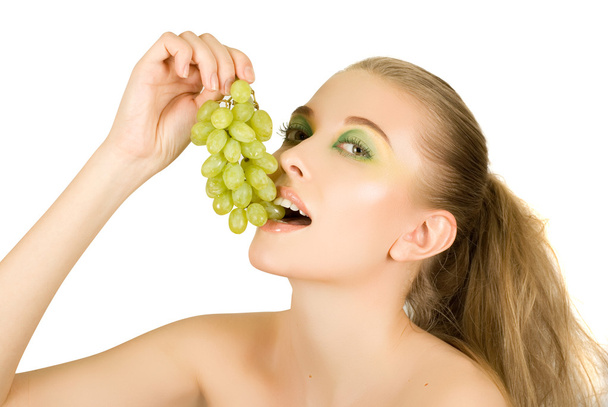 Mujer joven bonita con primer plano de la uva en el fondo blanco
 - Foto, imagen