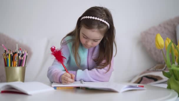 Frohes Mädchen macht Hausaufgaben und lächelt - Filmmaterial, Video