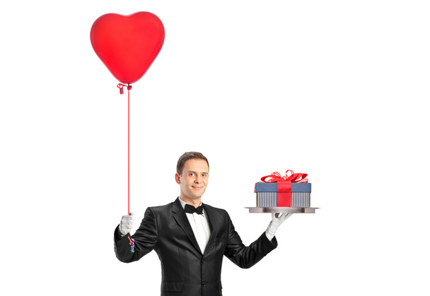 Waiter holding balloon and gift - Фото, изображение