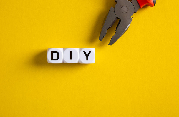 DIY-Konzept. Block mit DIY-Wort auf gelbem Hintergrund - Foto, Bild