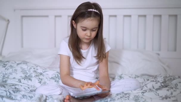 Κορίτσι δισκίο περιήγησης στο κρεβάτι - Πλάνα, βίντεο
