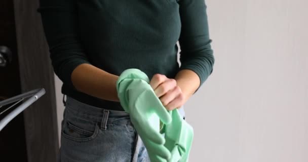 Αγνώριστο θηλυκό που βάζει γάντια λάτεξ ενώ ετοιμάζεται να καθαρίσει το σπίτι, πλυντήριο πιάτων στο σπίτι. Γυναίκα σύζυγος κάνει καθημερινή καθαριότητα στο σπίτι ρουτίνα. - Πλάνα, βίντεο