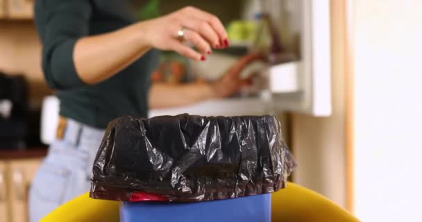 Woman throws in the trash uneaten spoiled products fruits, glasses, from the fridge, wife do daily house cleaning routine, food waste and loss - Footage, Video