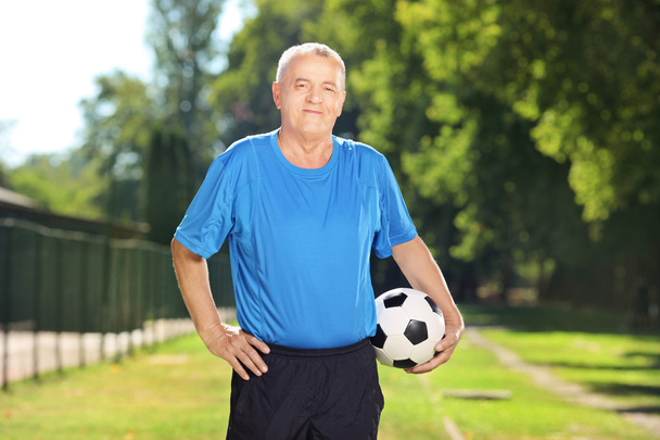 Mature man holding ball - Photo, image