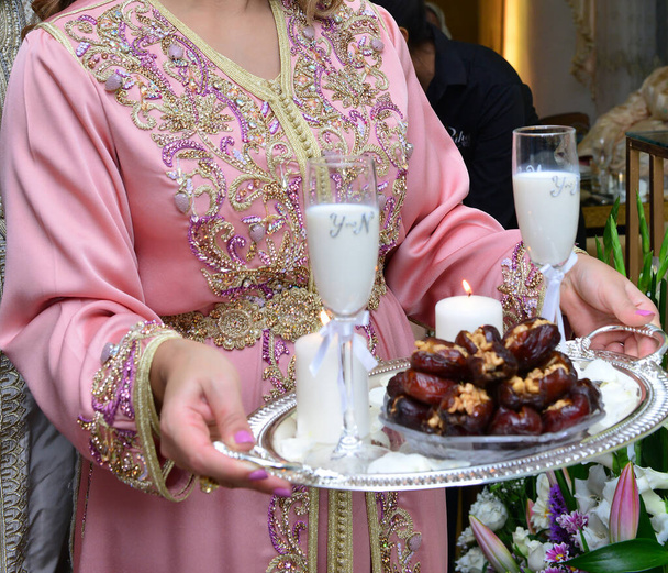 Арабская свадьба. Мать предлагает молоко и финики жениху и невесте - Фото, изображение