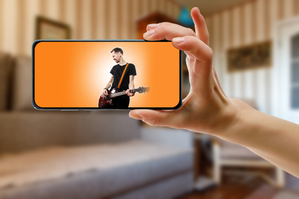 Online-Musikdarbietungen des Sängers zu Hause per Smartphone verfolgen. Musikvideo im Live-Stream - Foto, Bild
