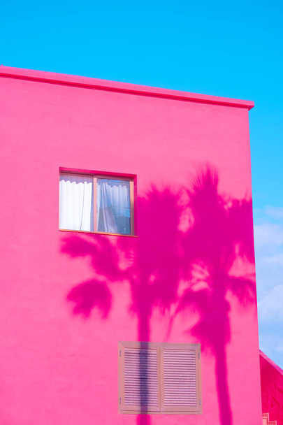 Mode tropische minimale locatie. Pink Hotel en Palm schaduwen. Blauwe zomerhemel. Canarische eilanden. Reisreclamebanner behang - Foto, afbeelding