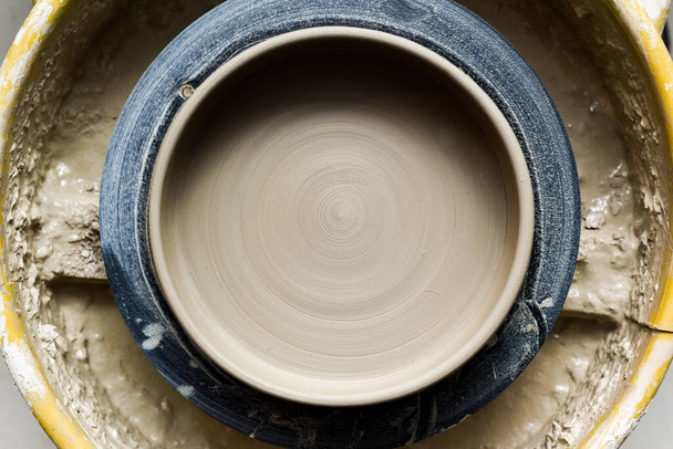 Töpferscheibe mit keramischen Werkzeugen zur Herstellung von Kunst- und Bastelobjekten aus Ton in einem Atelier - Foto, Bild