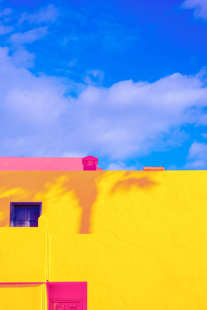 Ubicación tropical minimalista de moda. Yellow Synny Hotel, sombras de palmeras y cielo azul de verano. Islas Canarias. Papel pintado de viaje estética - Foto, imagen