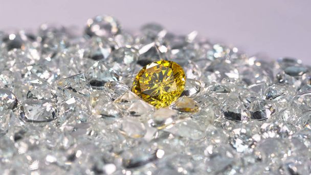 Żółte diamenty są umieszczane na stosie białych diamentów i obracają się. wideo 4k rozdzielczość sesji w studi - Zdjęcie, obraz
